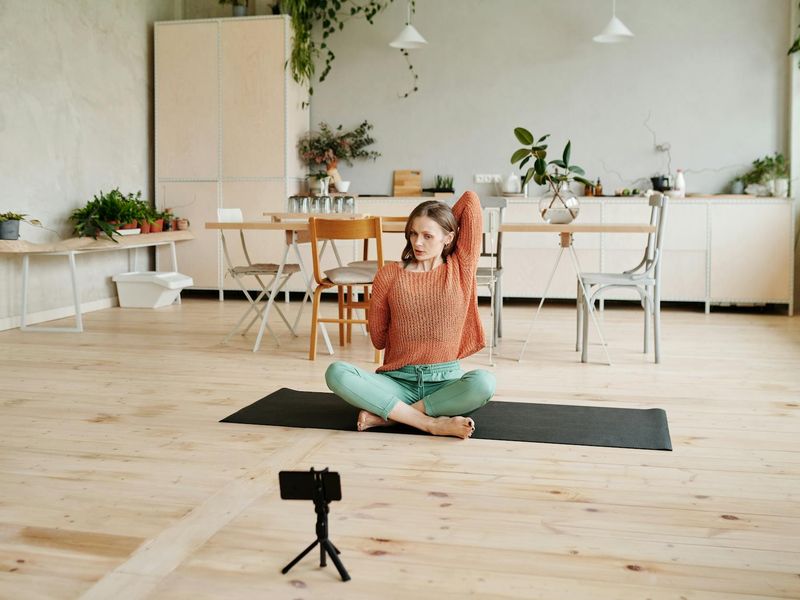 Cozy yoga studio with warm lighting and wooden floor.